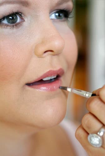Lippen werden mit einem feinen Pinsel geschminkt