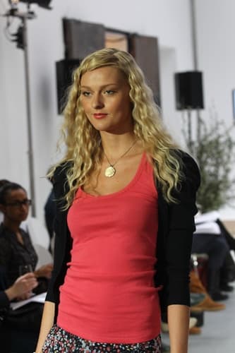 Model mit blonden Locken auf dem Laufsteg
